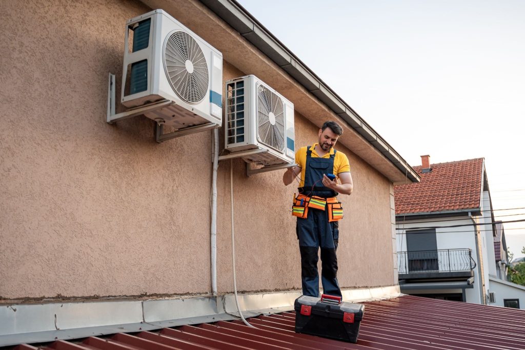 HVAC technician inspecting outdoor AC unit during routine servicing for improved efficiency